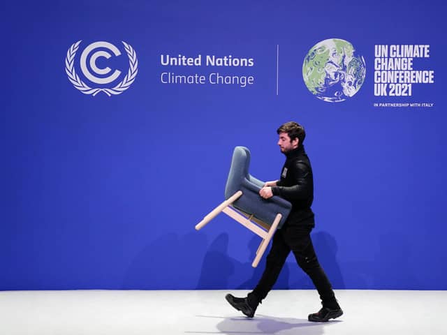 Staff remove chairs and dismantle one of the stages at COP26.