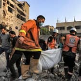 Palestinian civil defence members carry the body of a victim that was killed during Israeli bombardment after it was rescued from the rubble of a destroyed building in Khan Yunis in the southern Gaza Strip, amid the ongoing battles between Israel and the Palestinian group Hamas. (Photo by Mahmud HAMS / AFP) (Photo by MAHMUD HAMS/AFP via Getty Images)