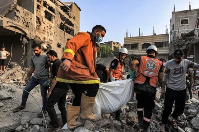 Palestinian civil defence members carry the body of a victim that was killed during Israeli bombardment after it was rescued from the rubble of a destroyed building in Khan Yunis in the southern Gaza Strip, amid the ongoing battles between Israel and the Palestinian group Hamas. (Photo by Mahmud HAMS / AFP) (Photo by MAHMUD HAMS/AFP via Getty Images)
