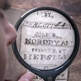 Curator Sarah Laycock uses a magnifying glass to inspect the last Charlotte Bronte miniature manuscript book known to be in private hands, as itk goes on display following its return to the Bronte Parsonage Museum in Haworth, Keighley, West Yorkshire, once the home of the Bronte family
Pic: Danny Lawson/PA