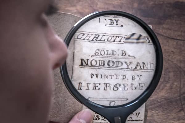 Curator Sarah Laycock uses a magnifying glass to inspect the last Charlotte Bronte miniature manuscript book known to be in private hands, as itk goes on display following its return to the Bronte Parsonage Museum in Haworth, Keighley, West Yorkshire, once the home of the Bronte family
Pic: Danny Lawson/PA