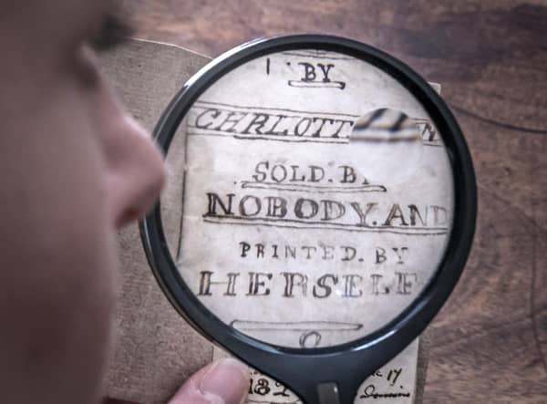 Curator Sarah Laycock uses a magnifying glass to inspect the last Charlotte Bronte miniature manuscript book known to be in private hands, as itk goes on display following its return to the Bronte Parsonage Museum in Haworth, Keighley, West Yorkshire, once the home of the Bronte family
Pic: Danny Lawson/PA