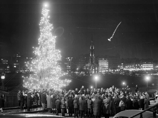 Crowds watch the lights of the Mound Christmas being turned on, with a view of Edinburgh's Princes Street, in 1966.