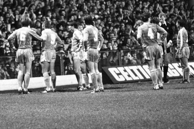 The referee halts play as the ill-tempered second half between Celtic and Rapid Vienna in 1984 leads to a bottle being thrown onto the field.