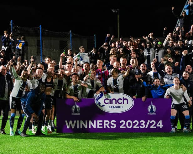 Falkirk players and coaching staff celebrate winning the cinch League 1 title.