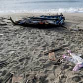 A baby's clothes and pieces of wood are washed up on the beach, two days after a boat of migrants sank off Italy's southern Calabria region.