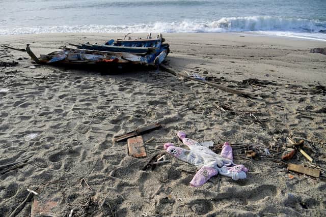 A baby's clothes and pieces of wood are washed up on the beach, two days after a boat of migrants sank off Italy's southern Calabria region.