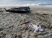 A baby's clothes and pieces of wood are washed up on the beach, two days after a boat of migrants sank off Italy's southern Calabria region.
