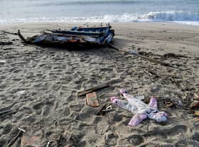 A baby's clothes and pieces of wood are washed up on the beach, two days after a boat of migrants sank off Italy's southern Calabria region.