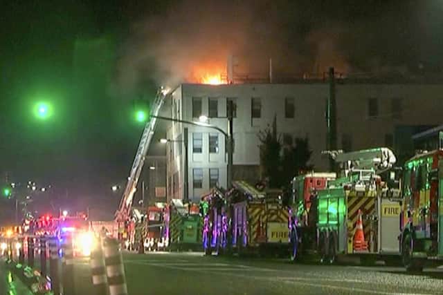 In this image made from video, fire trucks are positioned outside a hostel in central Wellington, New Zealand. Picture: NewsHub via AP