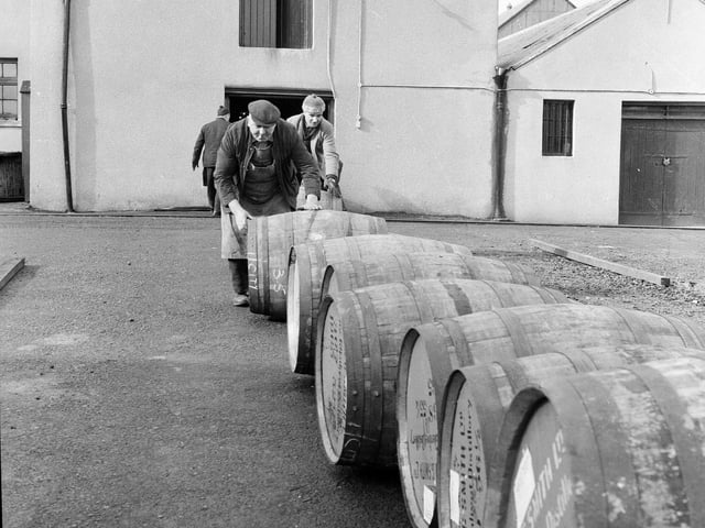 Moving barrels full of whisky into storage at the Glenlivet Distillery in 1967.