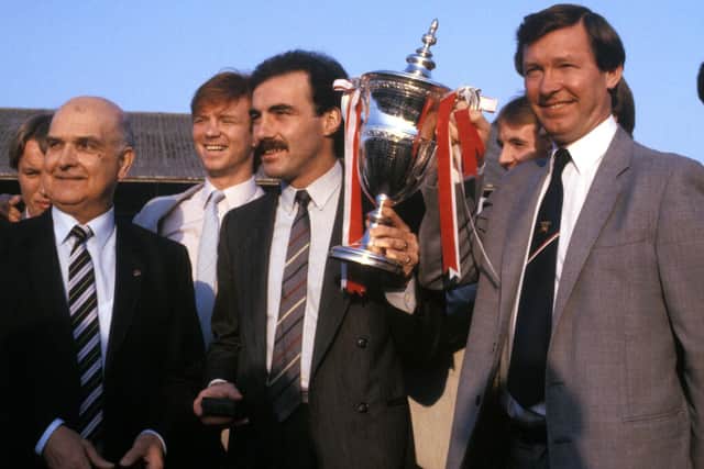 Aberdeen captain Willie Miller (centre) with the 1985 Premier League trophy after presentation by League President David Letham (left). Surrounded by manager Alex Ferguson and the Aberdeen squad
