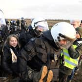 Police officers carry Swedish climate activist Greta Thunberg away from the edge of the Garzweiler II opencast lignite mine during a protest action by climate activists after the clearance of Luetzerath, Germany, Tuesday, Jan. 17, 2023. After the eviction of Luetzerath ended on Sunday, coal opponents continued their protests on Tuesday at several locations in North Rhine-Westphalia. (Roberto Pfeil/dpa via AP)