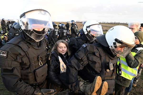 Police officers carry Swedish climate activist Greta Thunberg away from the edge of the Garzweiler II opencast lignite mine during a protest action by climate activists after the clearance of Luetzerath, Germany, Tuesday, Jan. 17, 2023. After the eviction of Luetzerath ended on Sunday, coal opponents continued their protests on Tuesday at several locations in North Rhine-Westphalia. (Roberto Pfeil/dpa via AP)