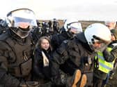 Police officers carry Swedish climate activist Greta Thunberg away from the edge of the Garzweiler II opencast lignite mine during a protest action by climate activists after the clearance of Luetzerath, Germany, Tuesday, Jan. 17, 2023. After the eviction of Luetzerath ended on Sunday, coal opponents continued their protests on Tuesday at several locations in North Rhine-Westphalia. (Roberto Pfeil/dpa via AP)