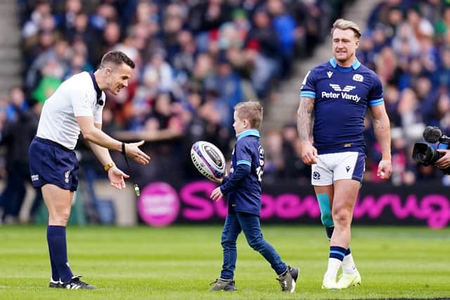 Scotland’s Stuart Hogg (right) watches as his son Archie delivers the match ball to referee Luke Pearce.