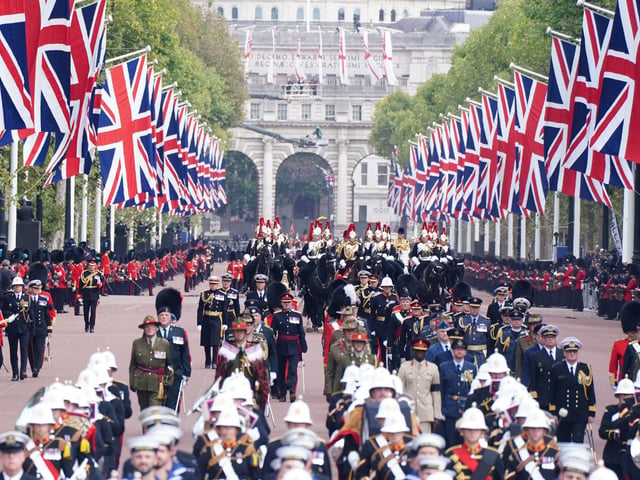 The State Gun Carriage carries the coffin of Queen Elizabeth II, draped in the Royal Standard with the Imperial State Crown and the Sovereign's orb and sceptre, in the Ceremonial Procession following her State Funeral at Westminster Abbey, London. Picture date: Monday September 19, 2022.