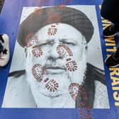 People step on a poster of Iranian President Ebrahim Raisi as they protest outside the United Nations building in New York City (Picture: Stephanie Keith/Getty Images)