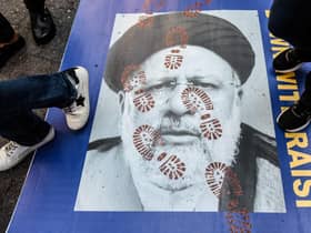 People step on a poster of Iranian President Ebrahim Raisi as they protest outside the United Nations building in New York City (Picture: Stephanie Keith/Getty Images)