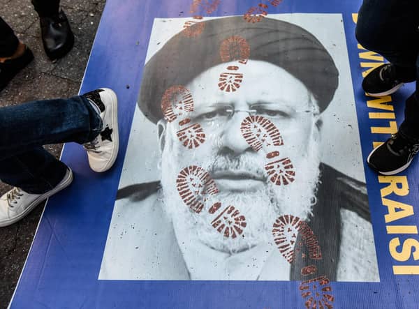 People step on a poster of Iranian President Ebrahim Raisi as they protest outside the United Nations building in New York City (Picture: Stephanie Keith/Getty Images)