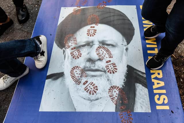 People step on a poster of Iranian President Ebrahim Raisi as they protest in front of the United Nations building in New York City (Image: Stephanie Keith/Getty Images)