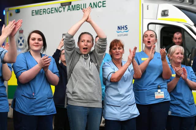 Staff from NHS Queen Elizabeth University Hospital gather outside A&E to clap for all carers who are working through the coronavirus emergency.