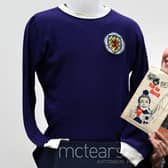 Auctioneer Amy Cameron with Jim Baxter's match worn jersey from Scotland's 3-2 win over then world champions, England, at Wembley in 1967. Picture: PA