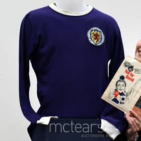 Auctioneer Amy Cameron with Jim Baxter's match worn jersey from Scotland's 3-2 win over then world champions, England, at Wembley in 1967. Picture: PA