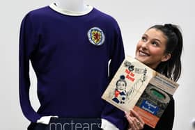 Auctioneer Amy Cameron with Jim Baxter's match worn jersey from Scotland's 3-2 win over then world champions, England, at Wembley in 1967. Picture: PA