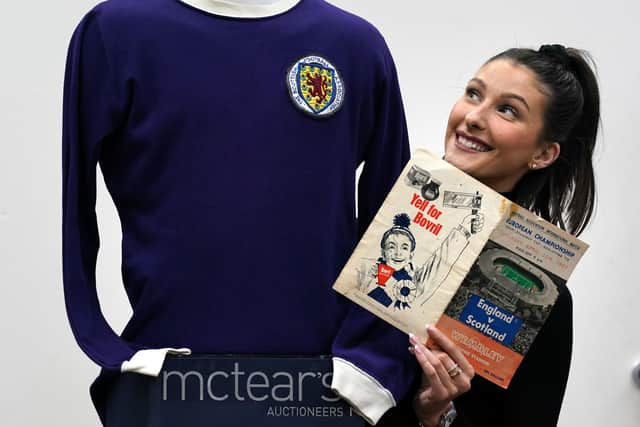 Auctioneer Amy Cameron with Jim Baxter's match worn jersey from Scotland's 3-2 win over then world champions, England, at Wembley in 1967. Picture: PA