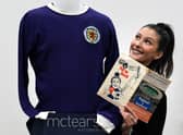 Auctioneer Amy Cameron with Jim Baxter's match worn jersey from Scotland's 3-2 win over then world champions, England, at Wembley in 1967. Picture: PA