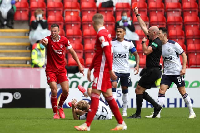 ABERDEEN, SCOTLAND - AUGUST 01: Andrew Considine of Aberdeen is shown a red card by referee Bobby Madden after fouling Scott Arfield of Rangers FC who goes down (Photo by Andrew Milligan/Pool via Getty Images)