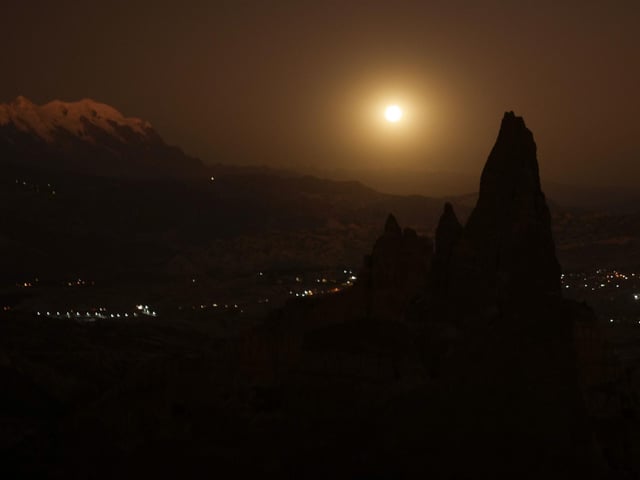 The full moon rises beside the snow capped Illimani Mountain, on the outskirts of La Paz, Bolivia, Tuesday, June 14, 2022. (AP Photo/Juan Karita)