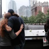 People embrace at the September 11th Memorial in New York City.