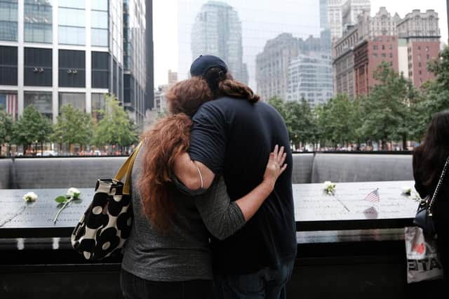 People embrace at the September 11th Memorial in New York City.