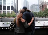 People embrace at the September 11th Memorial in New York City.