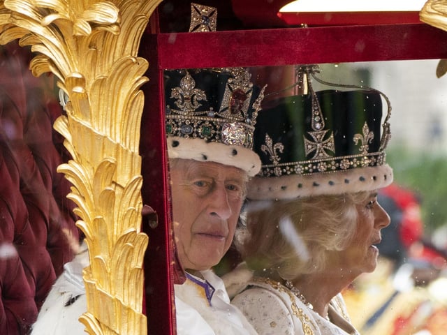 King Charles III and Queen Camilla are carried in the Gold State Coach, pulled by eight Windsor Greys, as the Coronation Procession passes through Parliament Square on its way to Buckingham Palace, London, following their coronation ceremony.