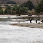 Officers of the Guardia Civil search through a river in the town of Aldea del Fresno, in the Madrid region on Monday, as a man was reported missing after his vehicle was swept away by an overflowing river during heavy rains.