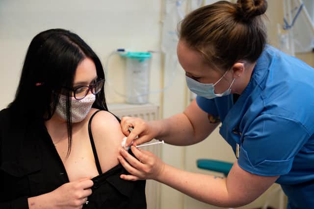 Elle Taylor, 24, an unpaid carer from Ammanford, receives an injection of the Moderna vaccine administered by nurse Laura French, at the West Wales General Hospital in Carmarthen.