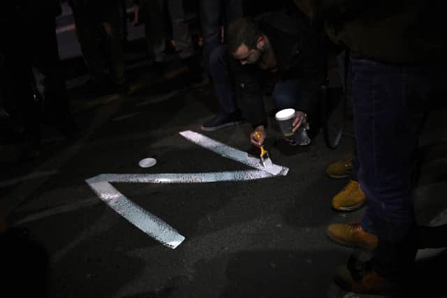 A protester paints the "Z" sign on a street, in reference to Russian tanks marked with the letter, during a rally organised by Serbian right-wing organisations in support of Russian invasion in Ukraine, in Belgrade March 4, 2022 (Image credit: Andrej Isakovic/AFP via Getty Images)