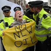 Police officers remove a climate activist protesting against the Rosebank oil field project in the North Sea off the coast of Scotland, outside the InterContinental London Park Lane in London in October. Picture: Daniel Leal/AFP via Getty Images