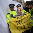 Police officers remove a climate activist protesting against the Rosebank oil field project in the North Sea off the coast of Scotland, outside the InterContinental London Park Lane in London in October. Picture: Daniel Leal/AFP via Getty Images