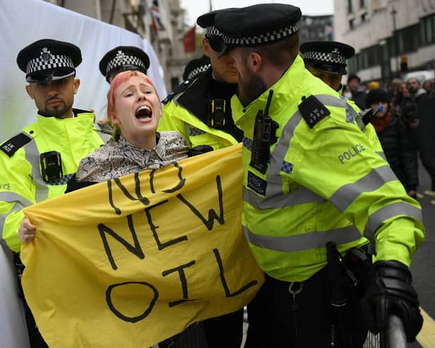 Police officers remove a climate activist protesting against the Rosebank oil field project in the North Sea off the coast of Scotland, outside the InterContinental London Park Lane in London in October. Picture: Daniel Leal/AFP via Getty Images