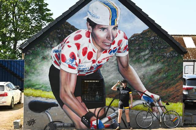 A cyclist takes a break at the new mural, created by Scottish artist Rogue One (aka Bobby McNamara)