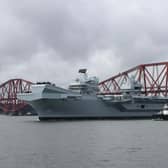 HMS Queen Elizabeth leaving Rosyth in Fife, Scotland, and sailing under the Forth bridge.