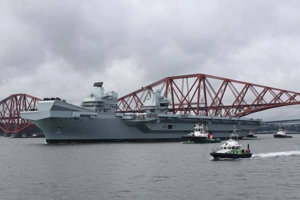 HMS Queen Elizabeth leaving Rosyth in Fife, Scotland, and sailing under the Forth bridge.