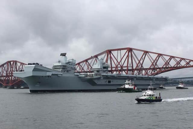 HMS Queen Elizabeth leaving Rosyth in Fife, Scotland, and sailing under the Forth bridge. She is due to return home to Portsmouth on July 30.