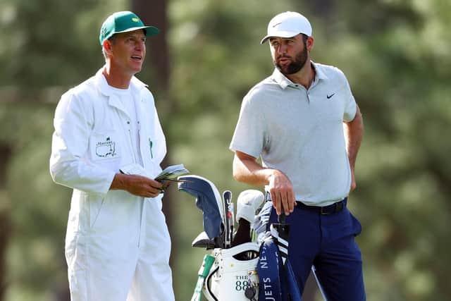 World No 1 Scottie Scheffler speaks with his caddie, Ted Scott, on the 14th hole during the first round of the 88th Masters. Picture: Andrew Redington/Getty Images.