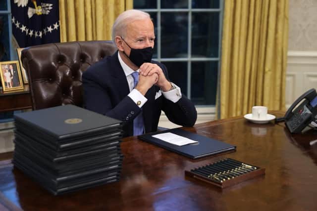 President Biden, pictured on his first day in the White House, with no button on the desk (Getty Images)