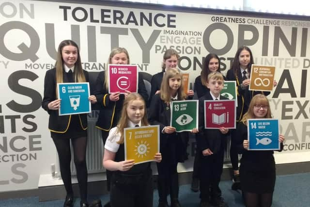 Children from Lornshill Academy show what actions can be taken to reach Net Zero by 2045.